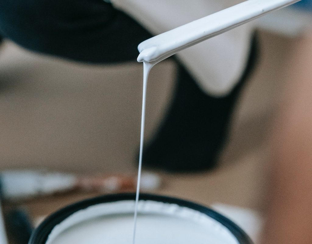 white paint primer dripping into can