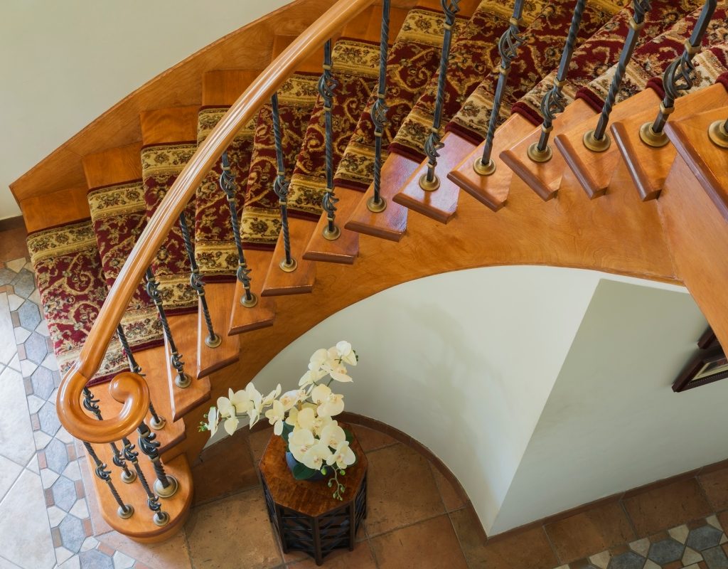 Wooden spiral staircase with fancy rug