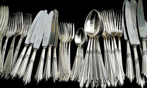 Piles of silverware on a black surface