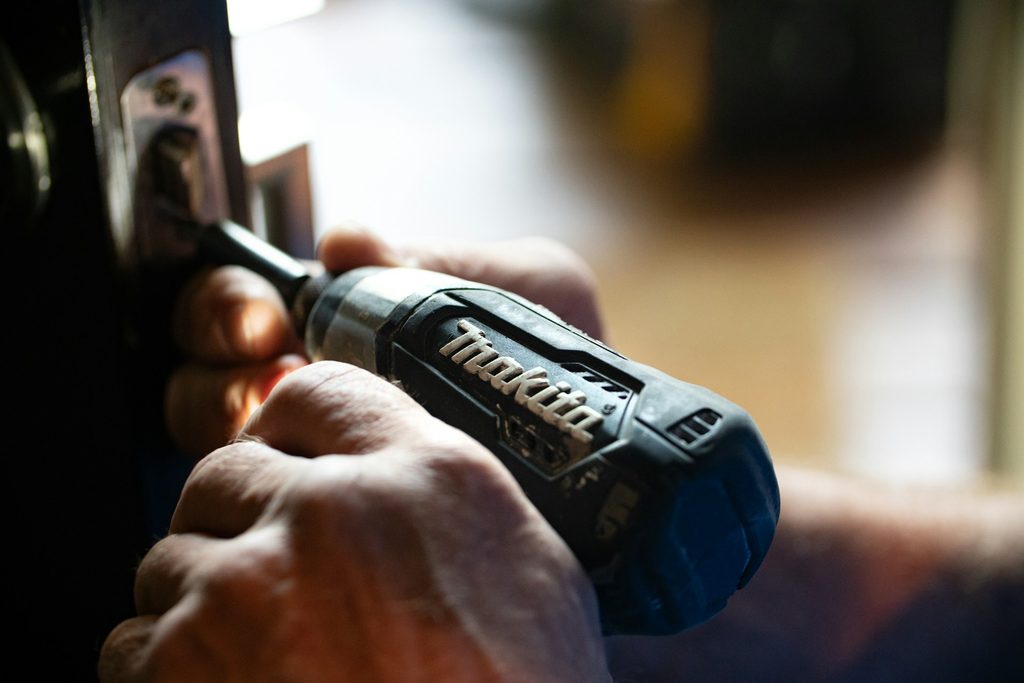 man using an electric drill on a screw