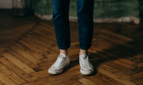 Person in sneakers standing on parquet floors