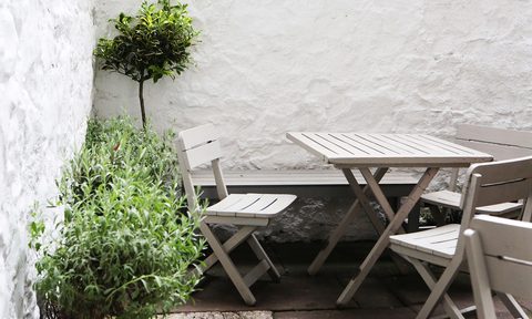 Small patio with light colored walls and folding chairs