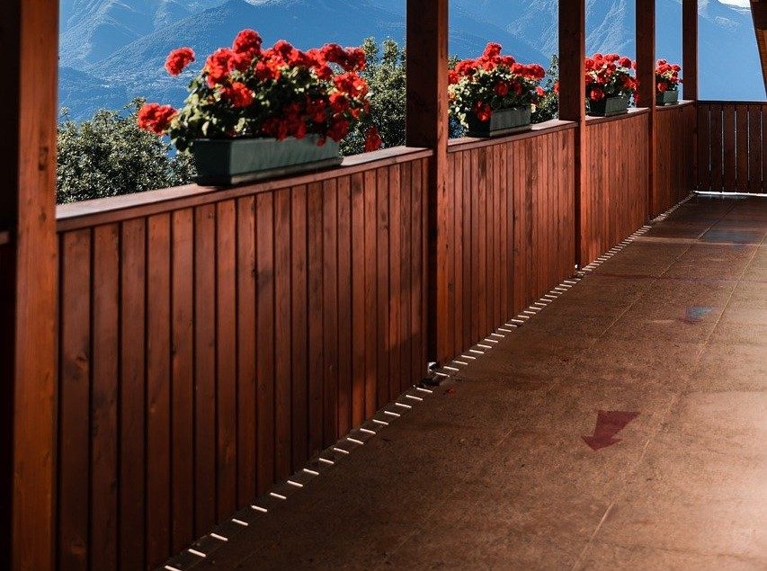 wood privacy deck railing with red flowers