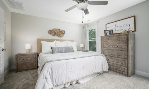 White farmhouse bedroom with minimalist design and a ceiling fan