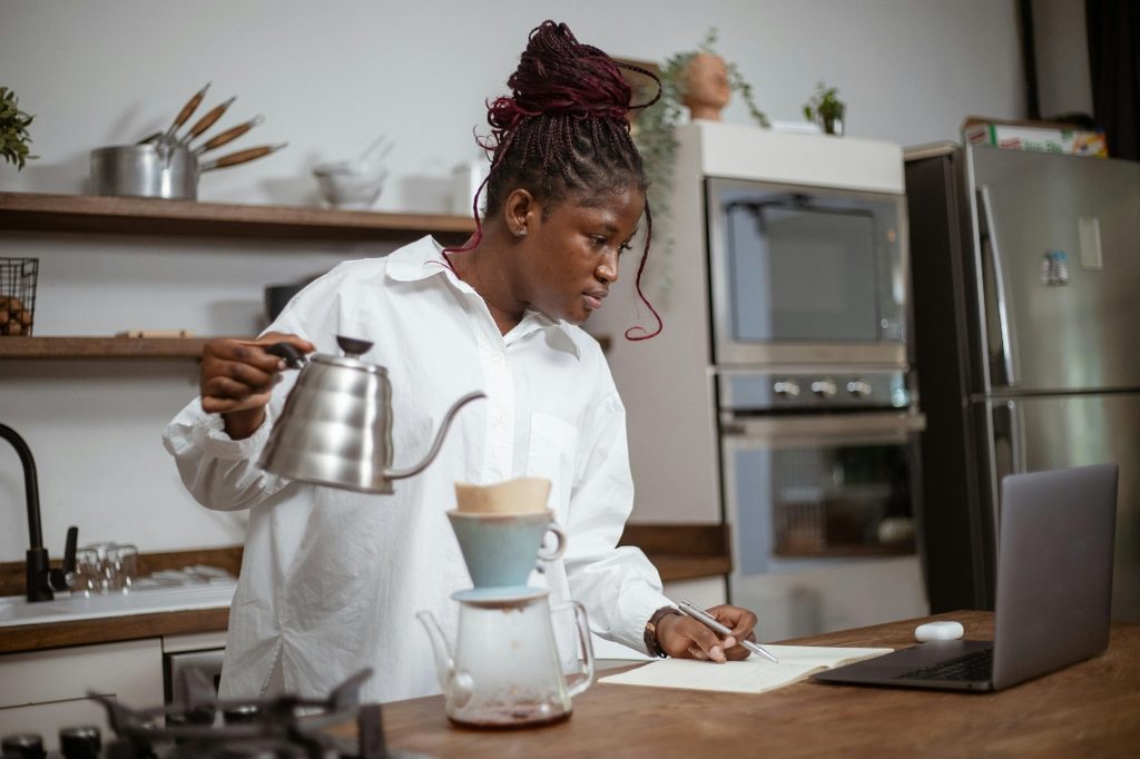 woman in kitchen using pour over coffee maker