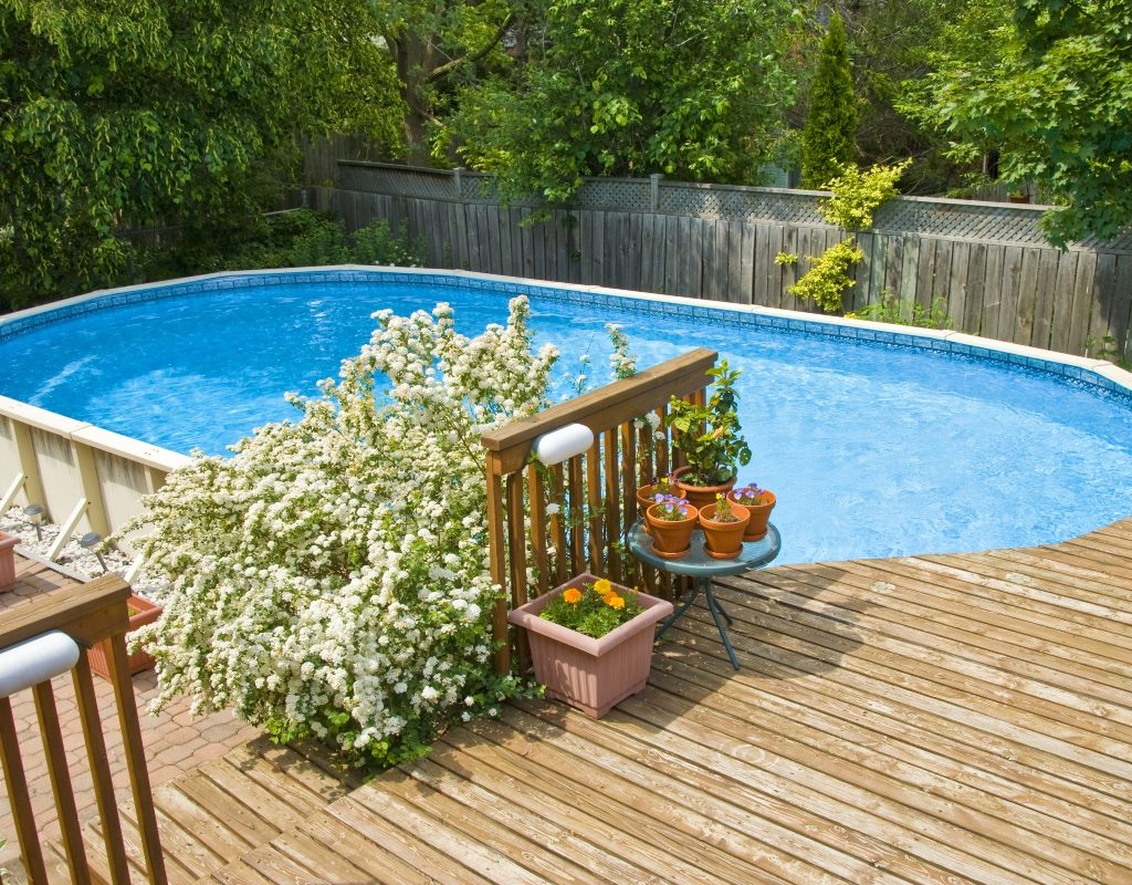 Above-ground pool with partial deck in backyard