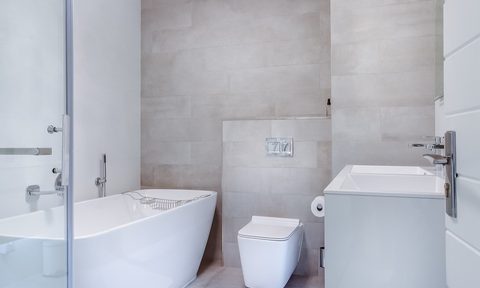 Modern minimalist bathroom with soaking tub and square toilet