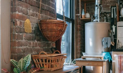 Water heater in kitchen with brick wall and baskets