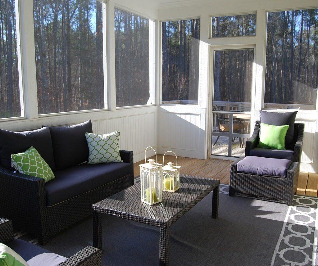 sunroom porch with dark furniture and white trim