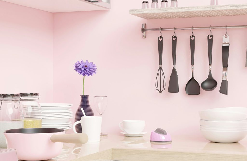 Pink kitchen wall with black and white utensils
