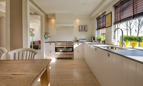 Light colored kitchen with wood table and wood floors