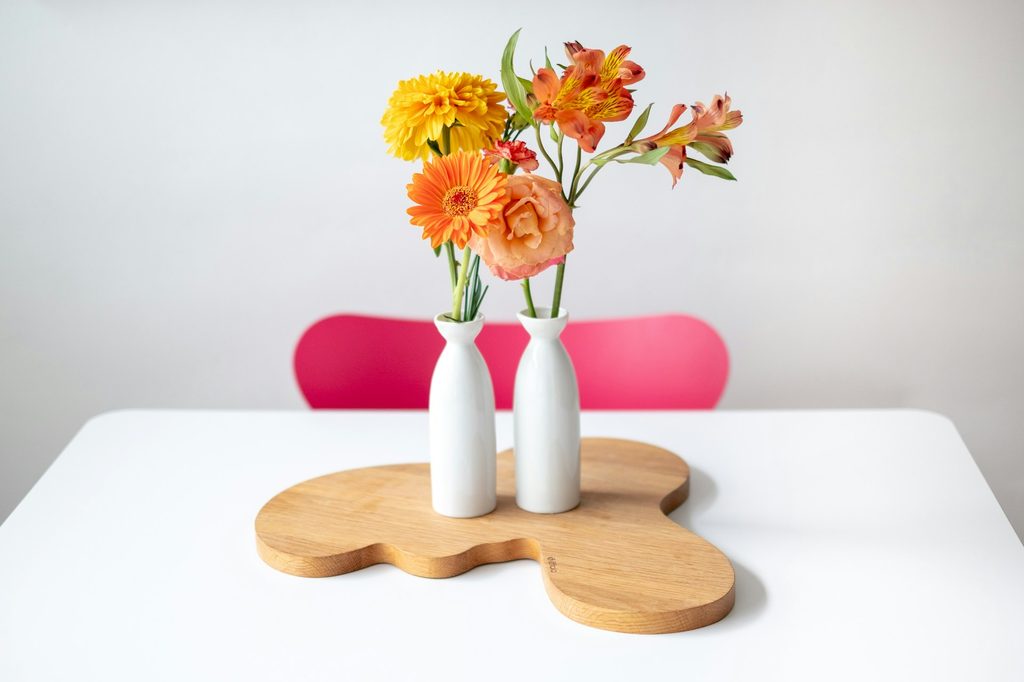 Yellow flowers on a white table with a hot pink chair