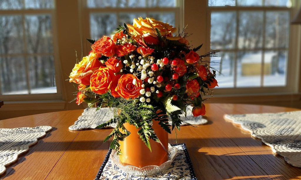 Fall colored flowers in a vase on a table