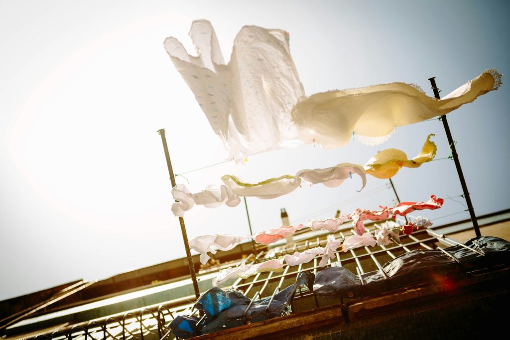white laundry hanging on a clothes line from a balcony