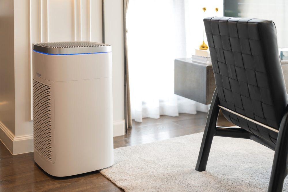 Large air purifier next to a dark colored chair