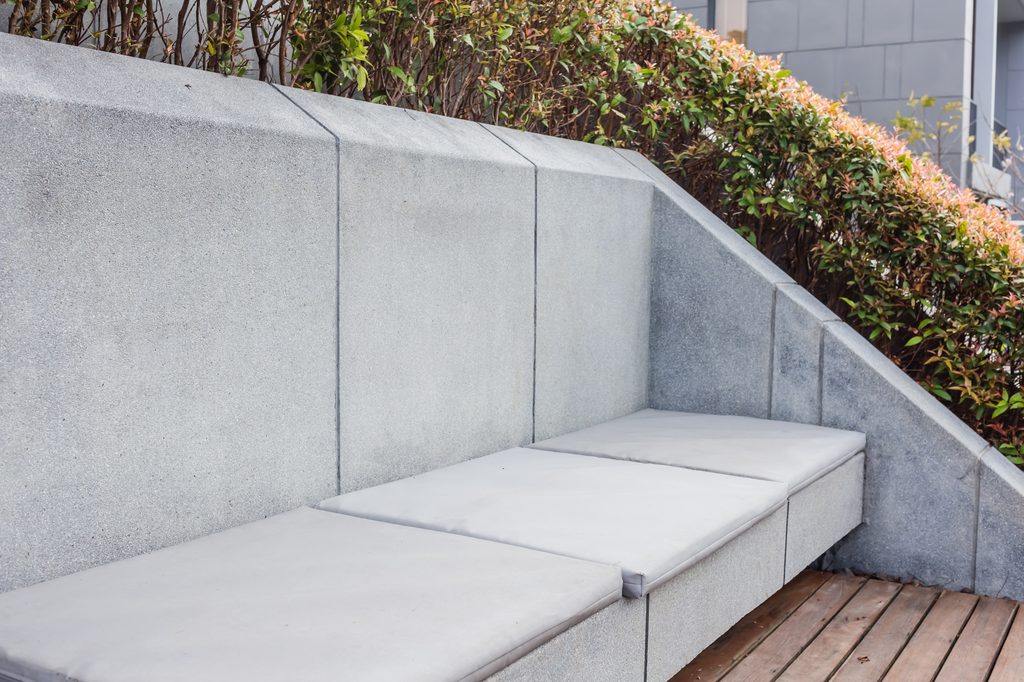 Built-in concrete bench in backyard hardscaping