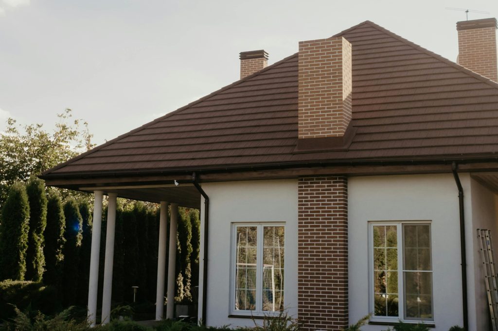small suburban house with brick chimney and brown roof