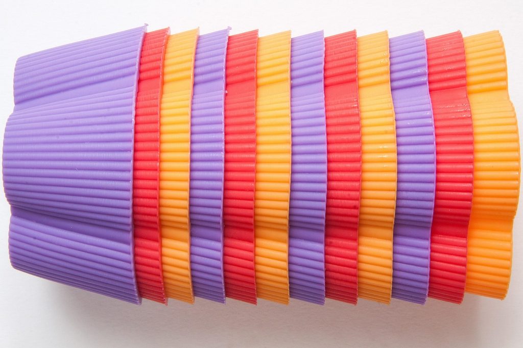 Multicolored silicone muffin cups in a stack on its side.