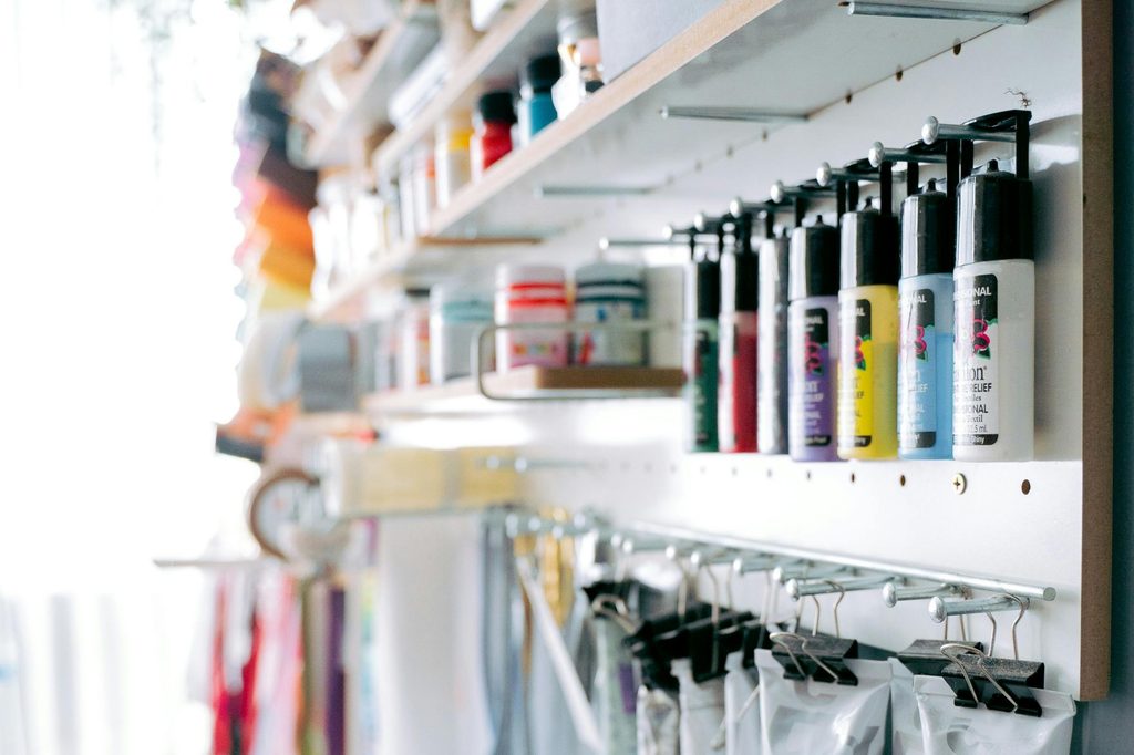 pegboard wall with paint and craft supplies