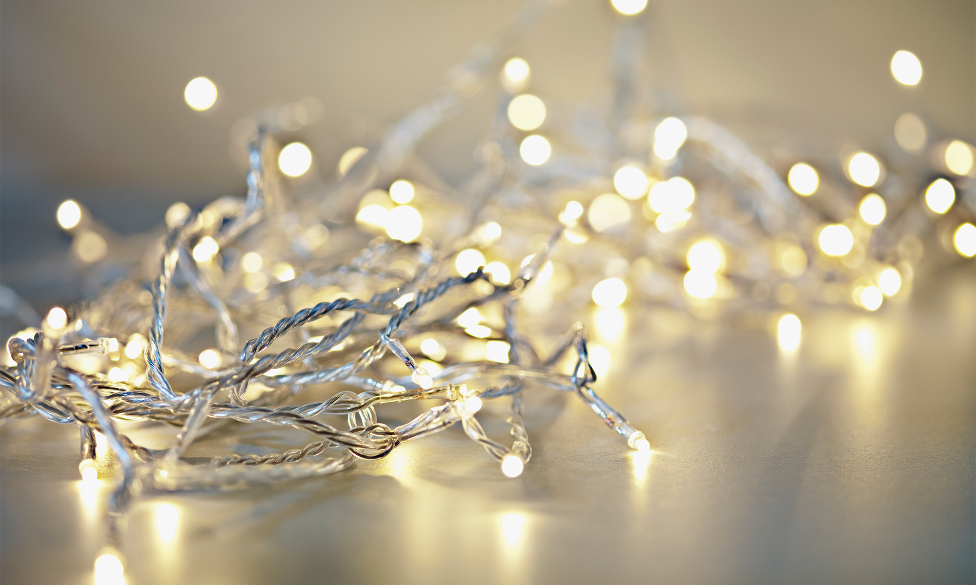 String of tangled fairy lights on a gray reflective surface