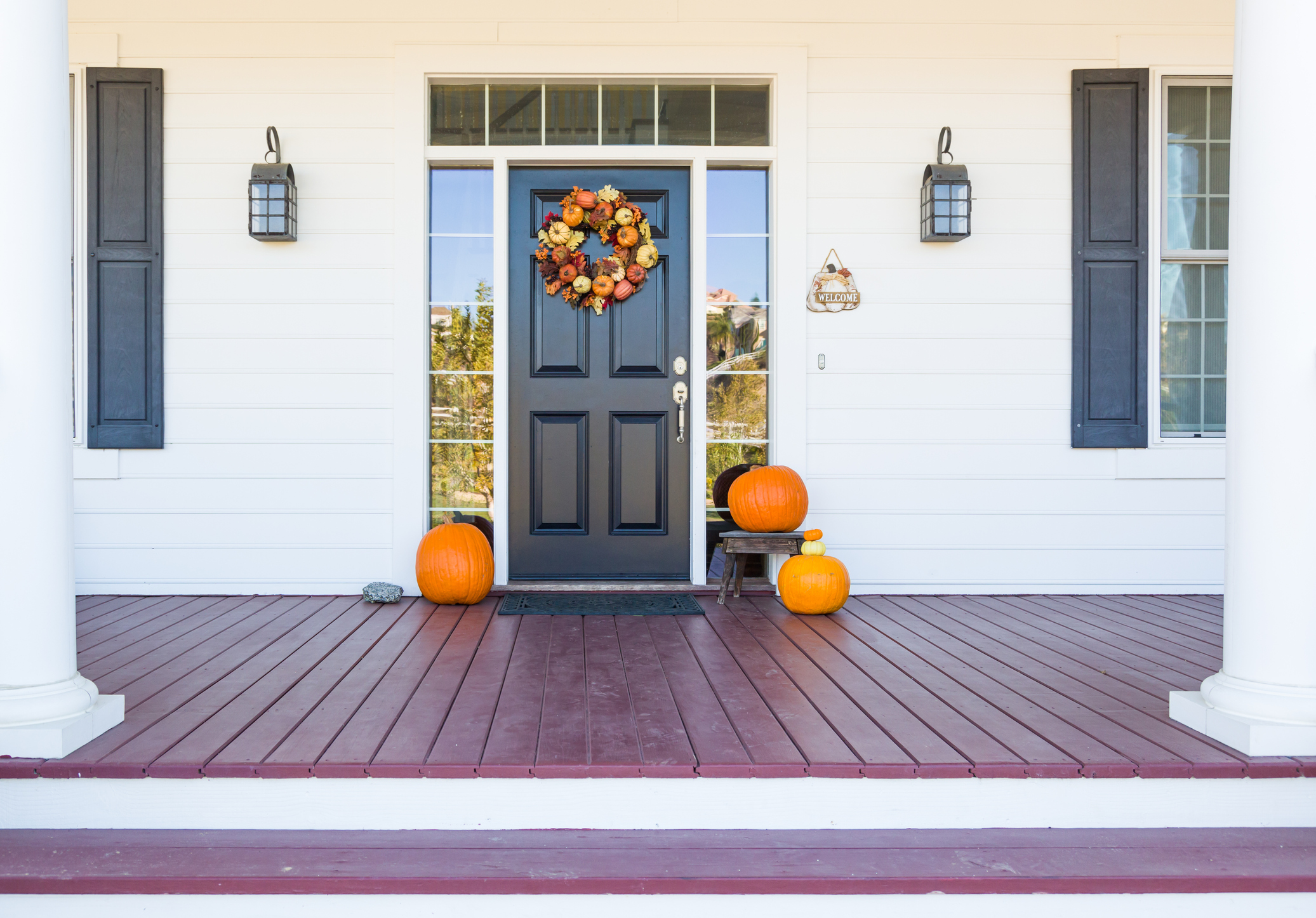 Fall front door decor with a wreath and pumpkins