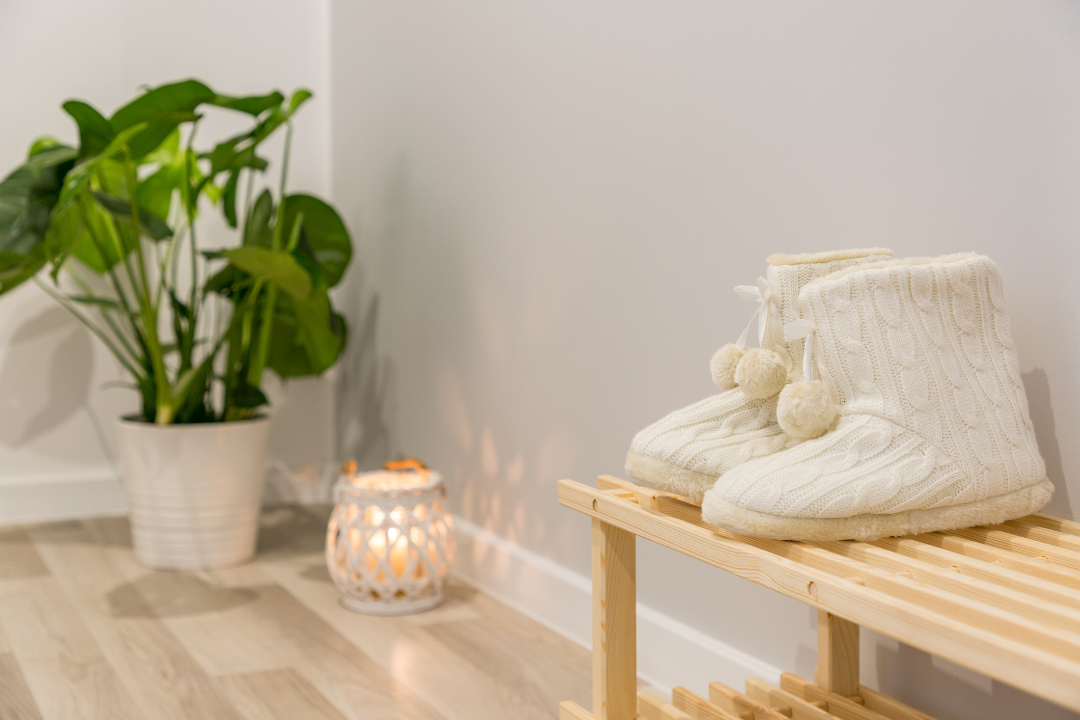 shoe rack bench near plant and candle