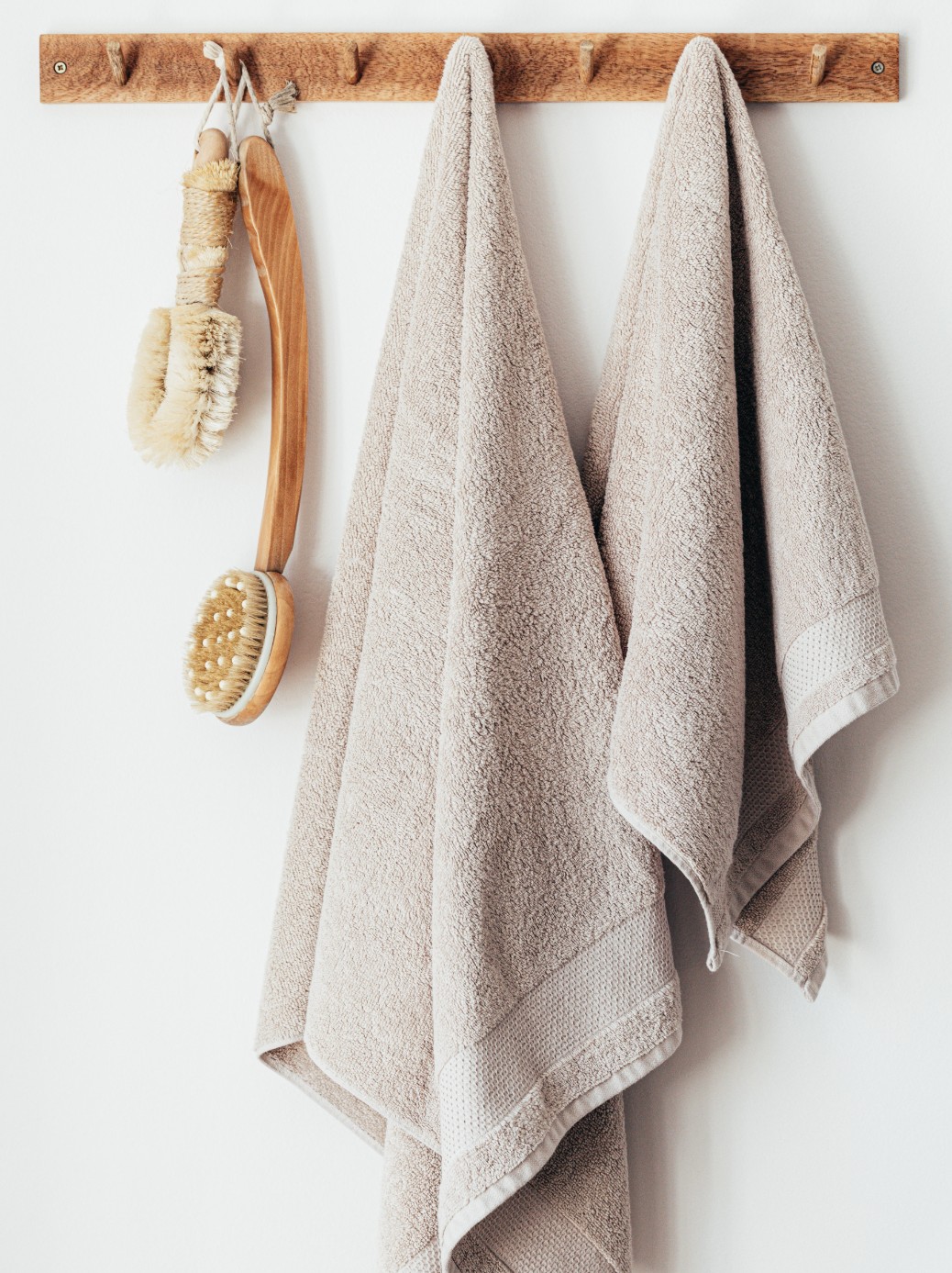 Two bathroom towels hanging on hooks