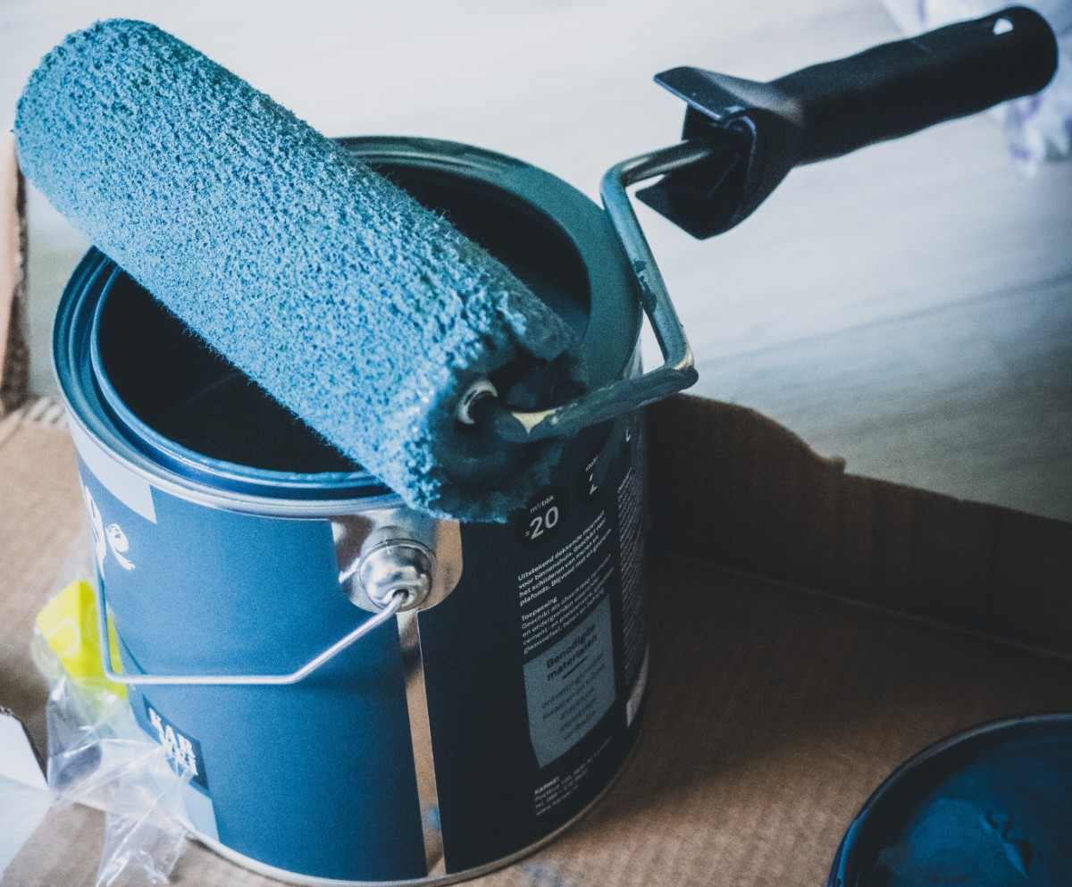 Paint roller with paint can on floor