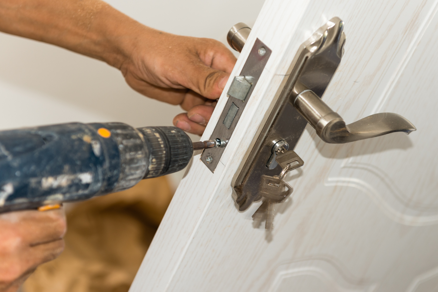 person installing deadbolt on door