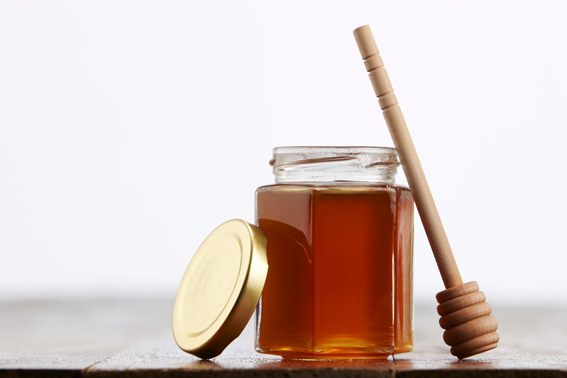 Jar of honey with a serving stick
