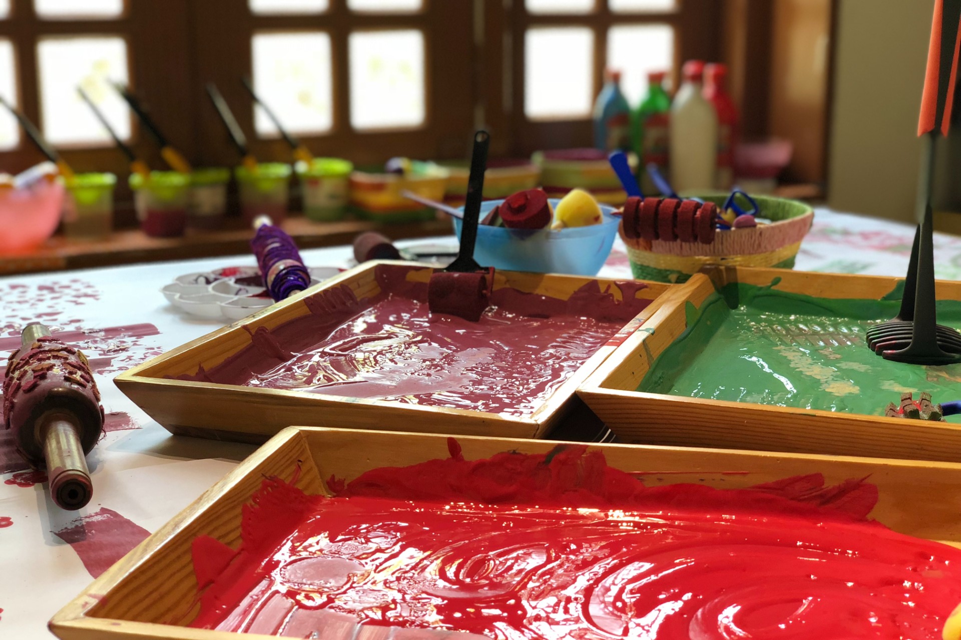 Three paint trayswith paint colors of red, green, and burgundy in them