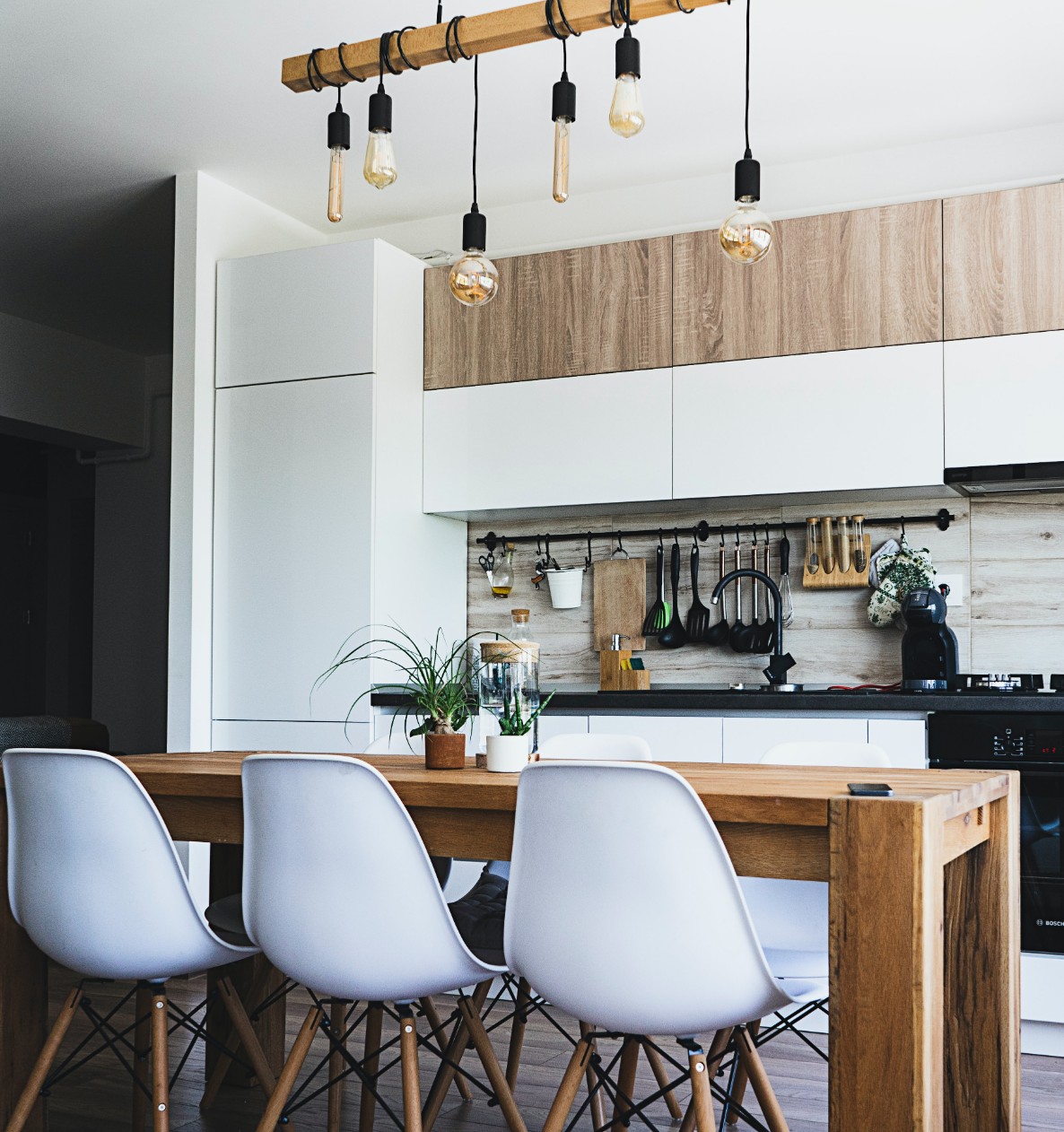 Kitchen with wooden table, chairs, and overhead lights