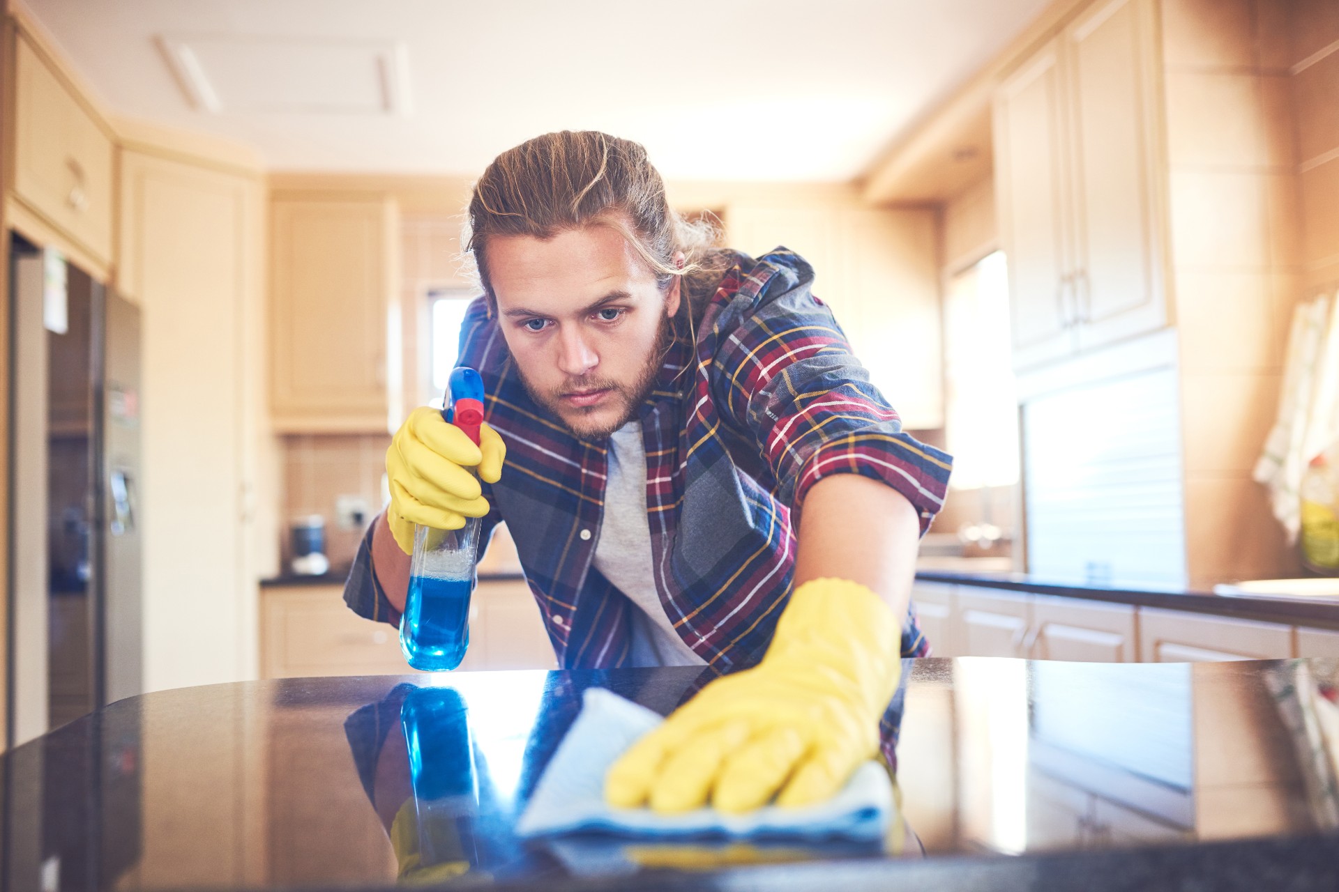 Man cleaning counter with spray bottle
