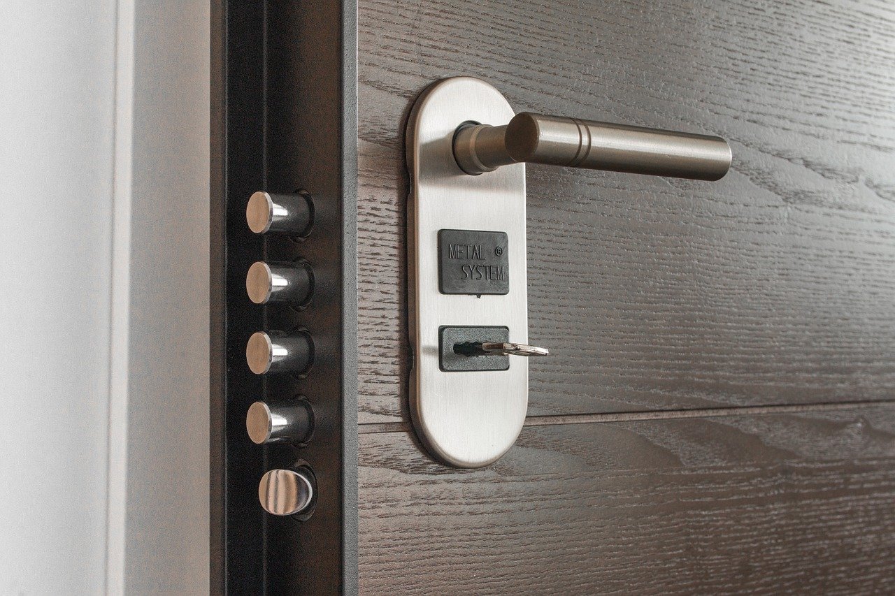 Wooden door with silver handle and multiple dead bolt locks