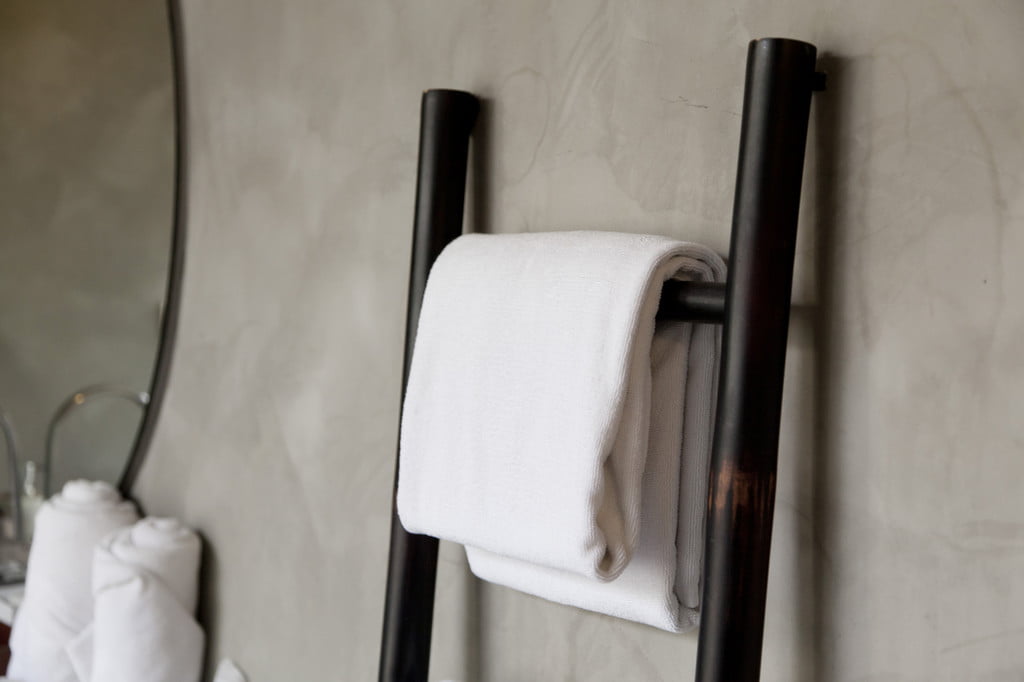 white towel hanging on bathroom towel ladder