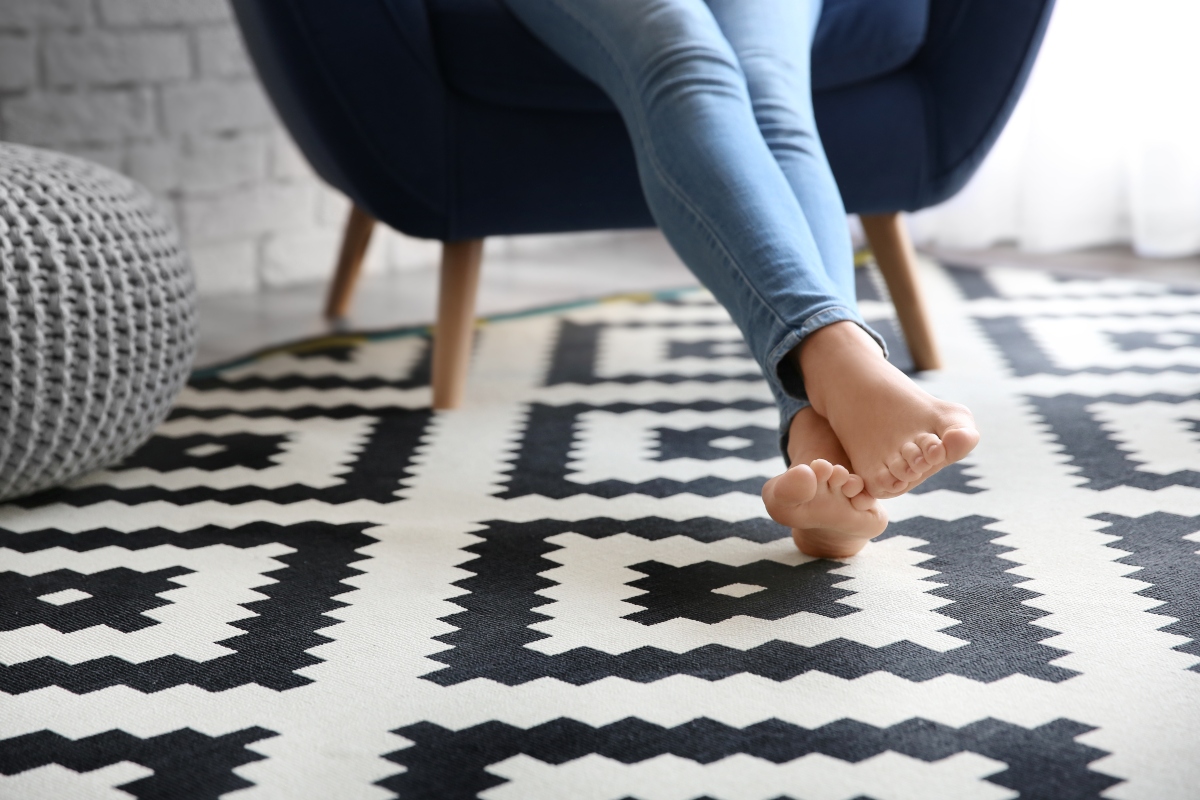 feet resting on black and white vinyl tile floor