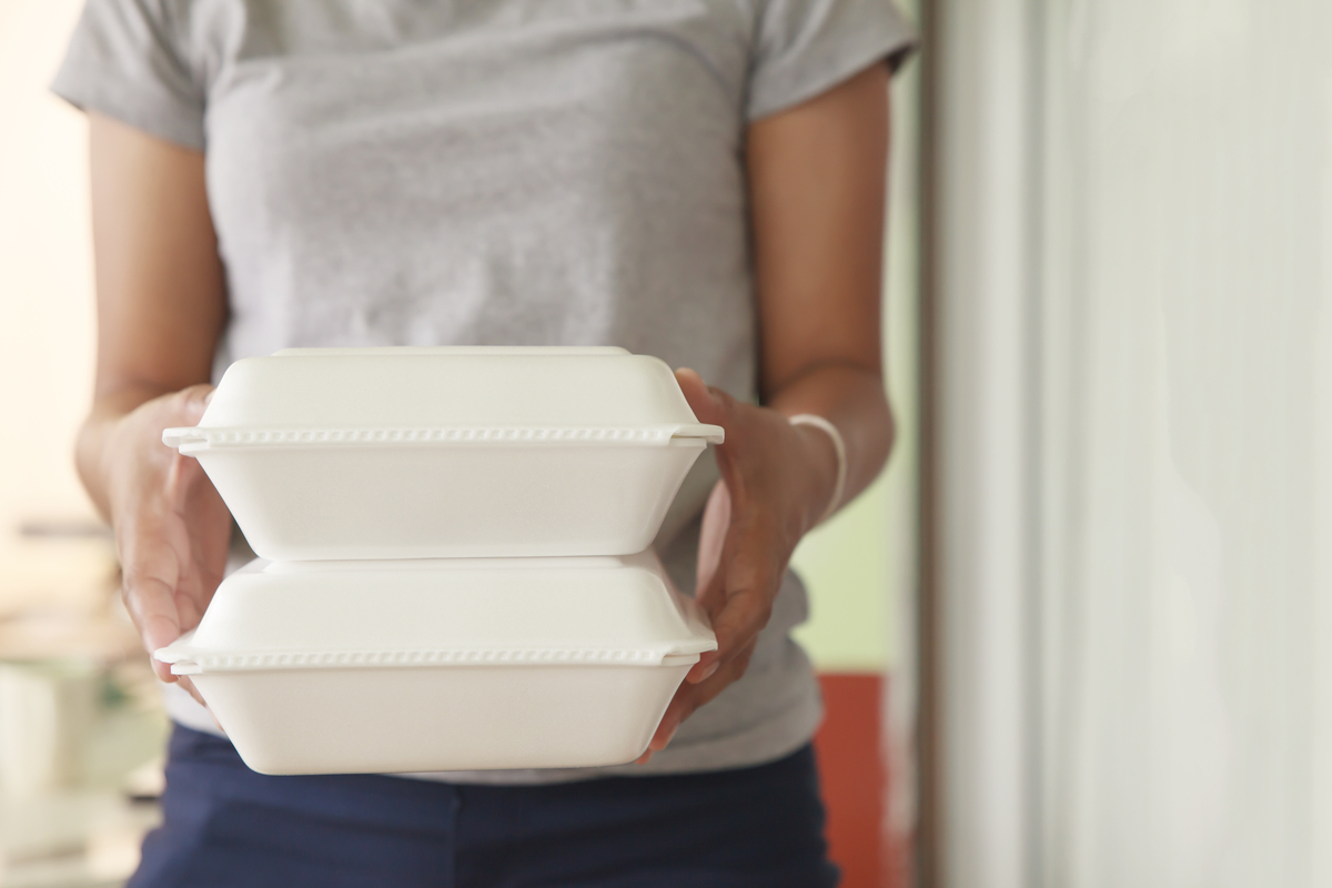 Person holding two Styrofoam carry-out containers