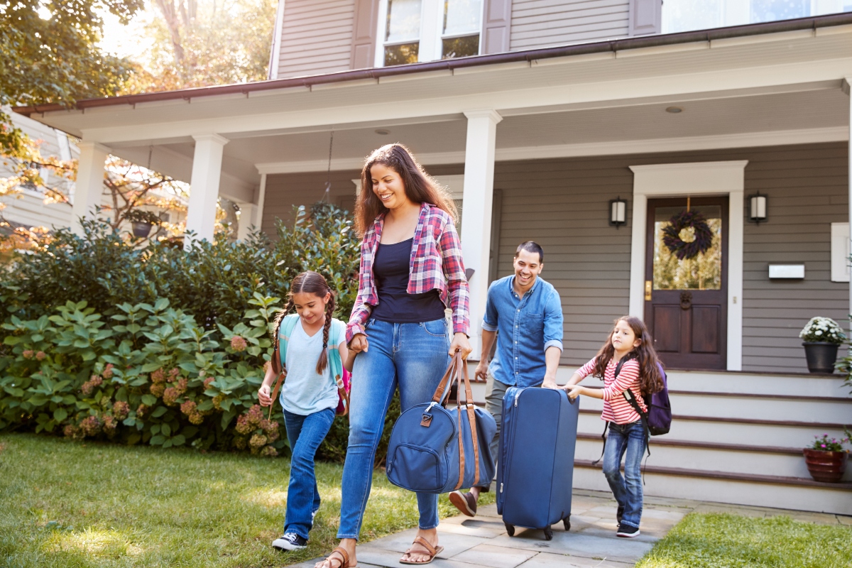 family carrying luggage and leaving home