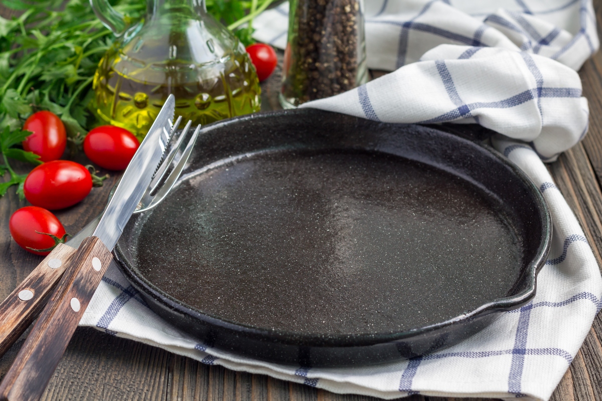 cast iron pan on table near vegetable oil