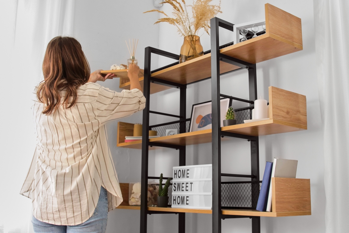 woman using home decor to style shelves