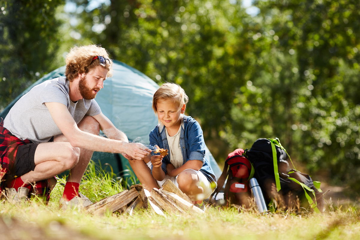 dad and daughter starting a campfire