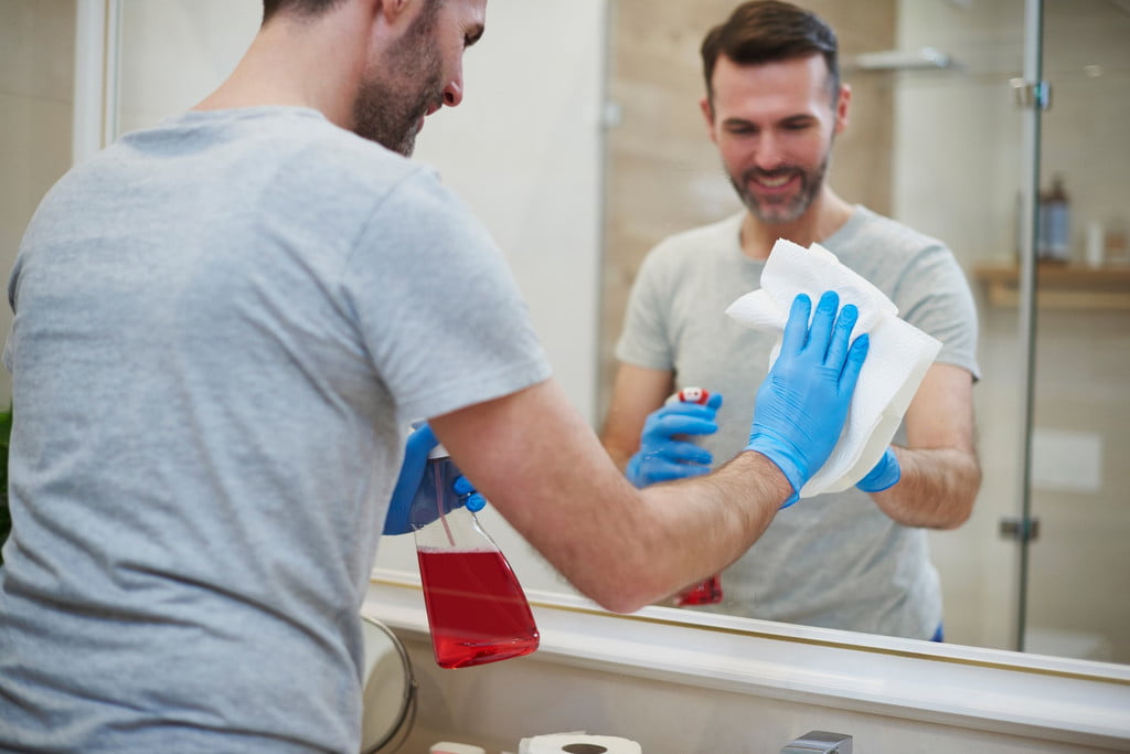 Person cleaning a mirror