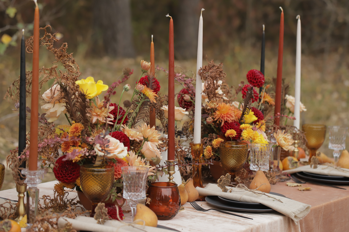 Fall outdoor table with mums and other flowers in centerpieces