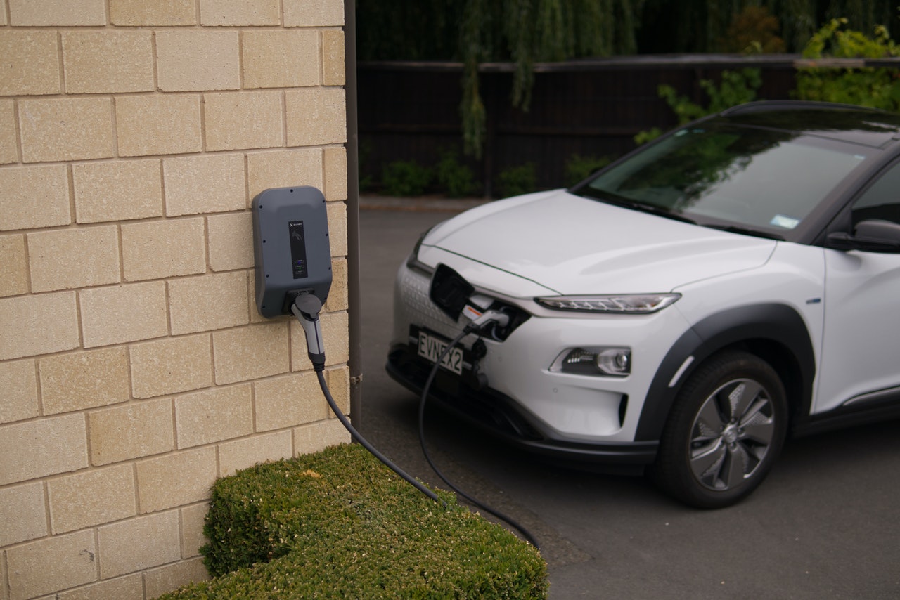 electric vehicle connected to charger on brick wall
