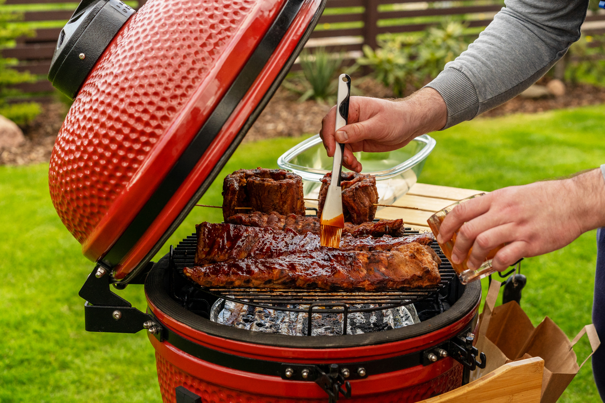Man cooking with small red grill