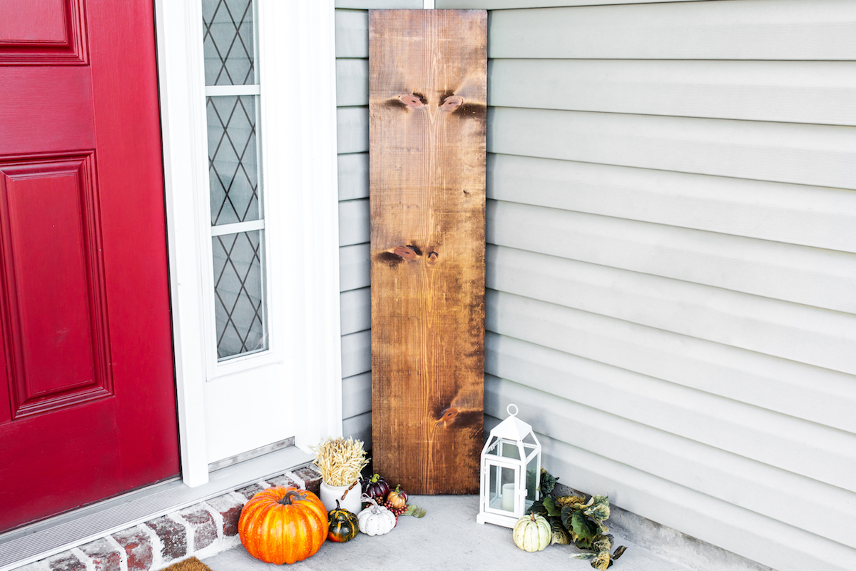 fall wood sign by front door with pumpkins
