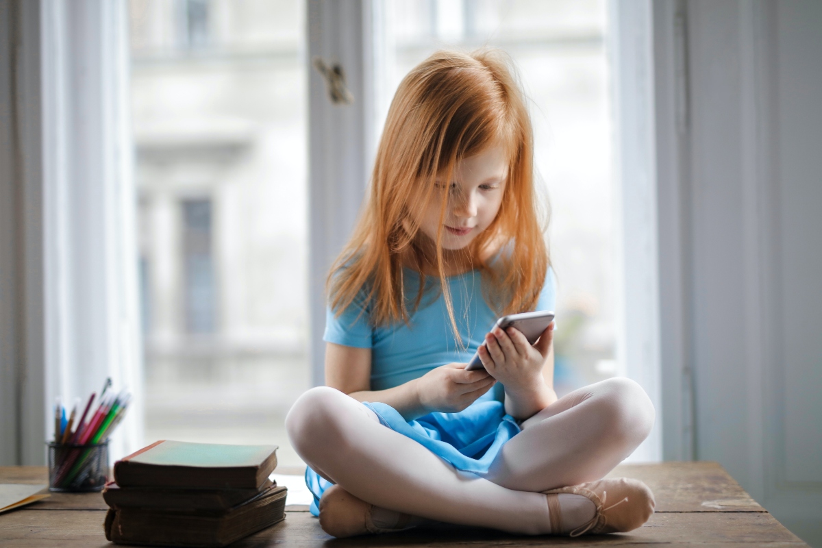 young girl playing on iphone