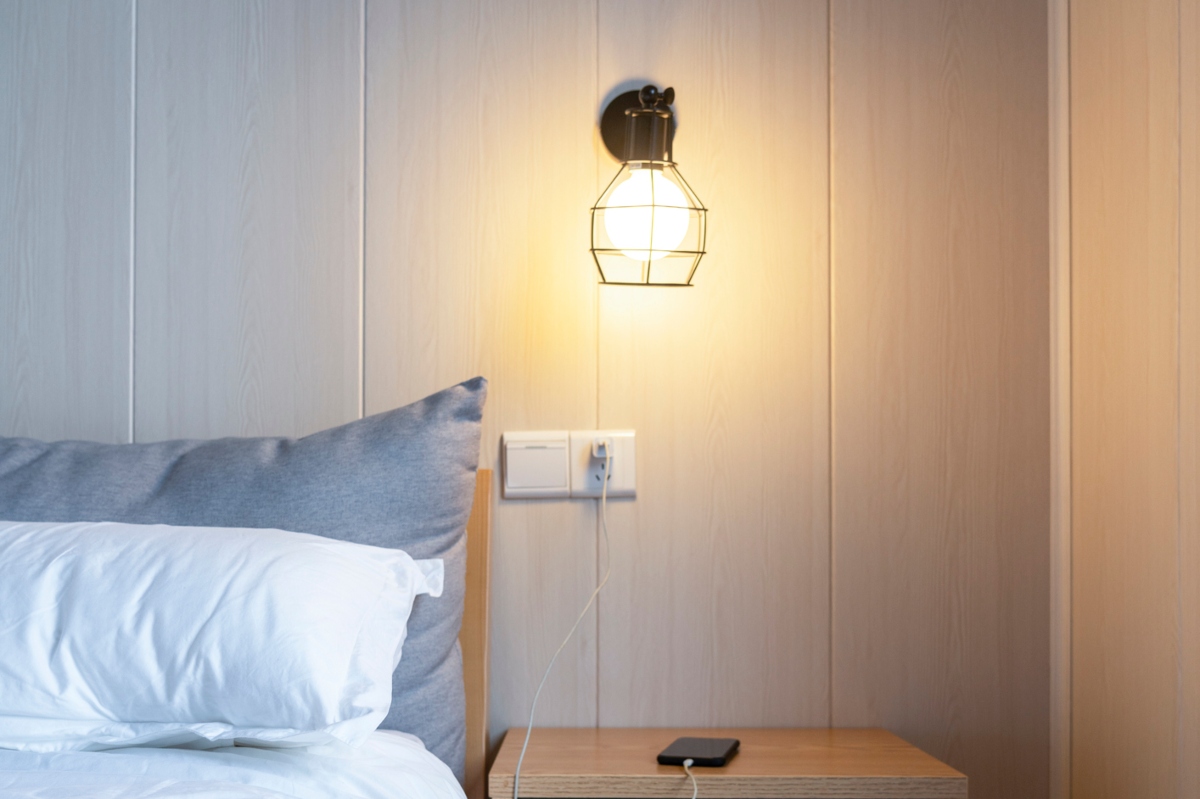 wall sconce above nightstand in bedroom