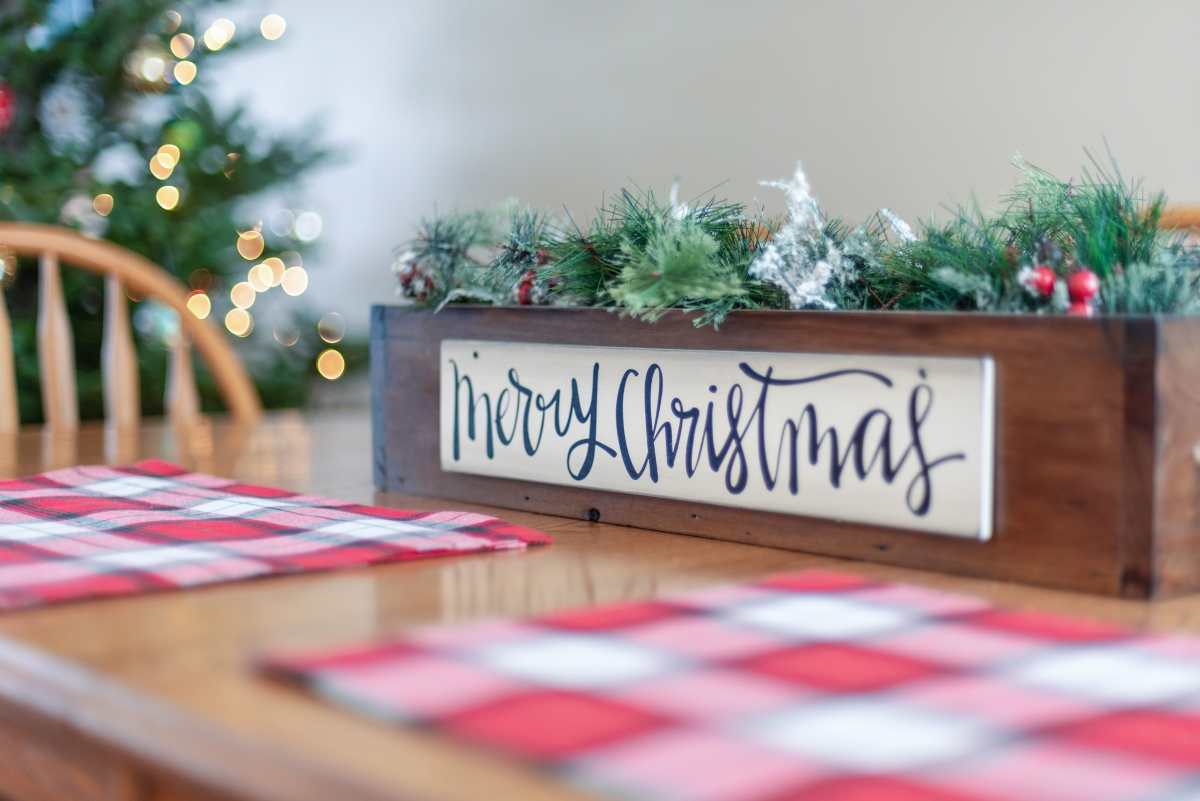 Christmas sign on dining table with plaid placemats