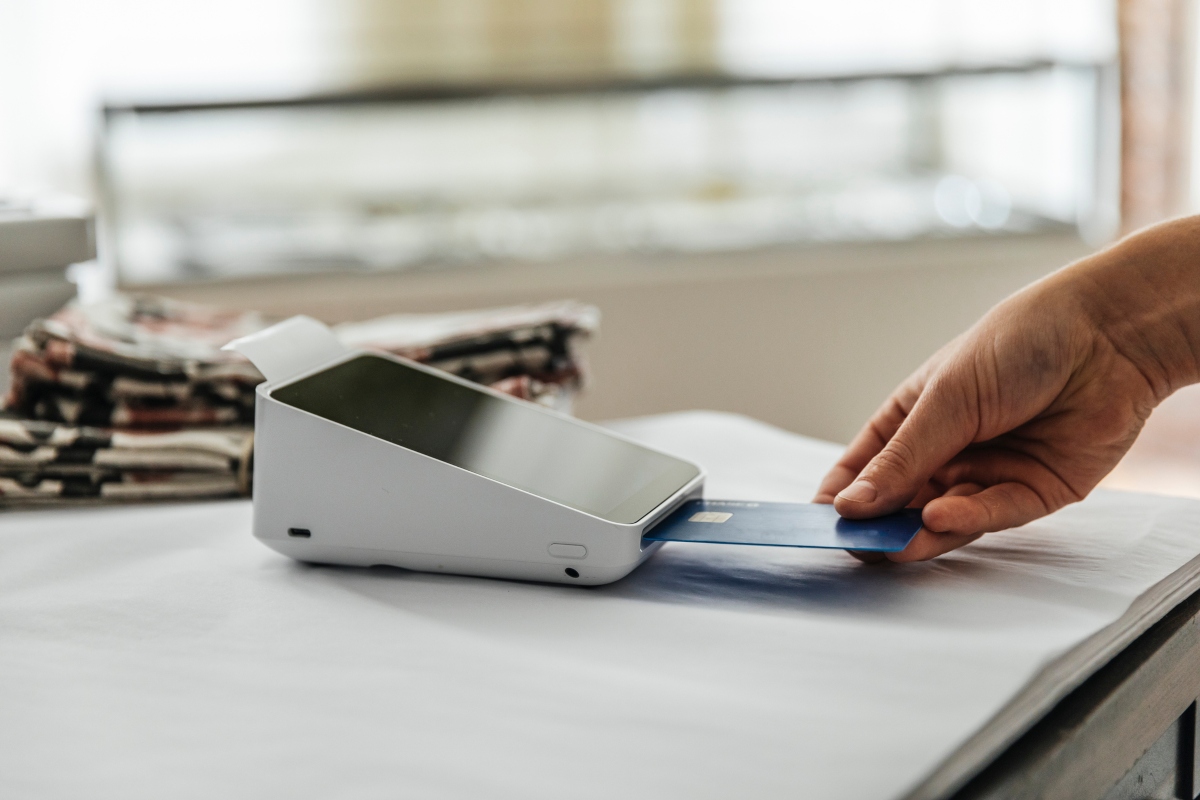person using a credit card at a store card reader